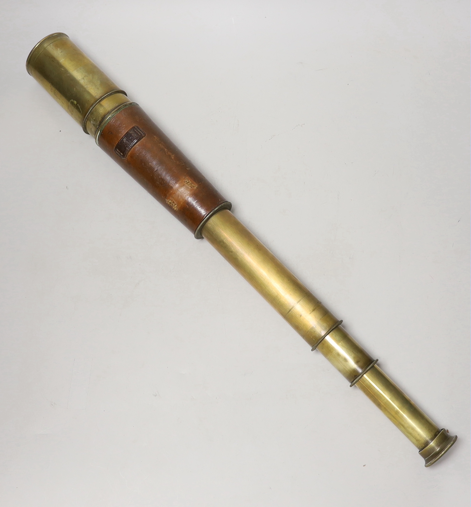 A WWI three draw brass telescope with sun shade and leather outer cover by Taylor Taylor Hobson Ltd.